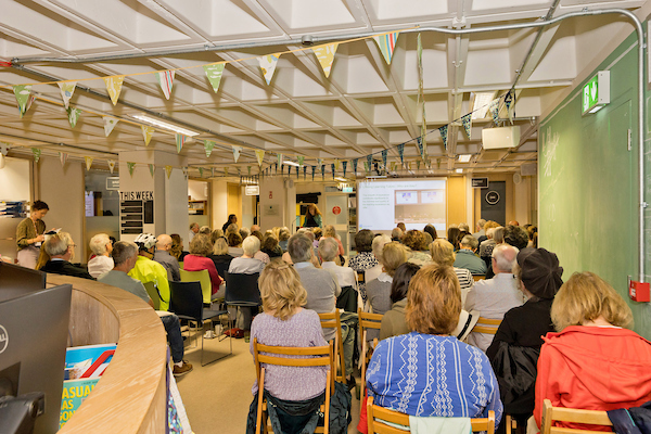 Students in the Learning Space facing a speaker at a projector